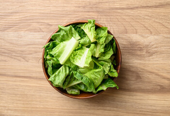 Organic cos romaine lettuce in wooden bowl, Food ingredient for healthy salad