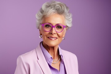 Beautiful senior woman. Portrait of a beautiful senior woman in glasses on a purple background.