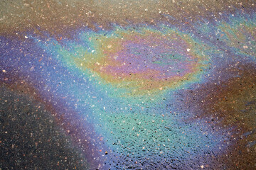 Colored spots of oil or gasoline on the asphalt as a texture or background.