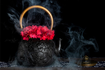 The black teapot with flowers was shrouded in smoke