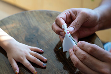 Taking out a nail sticker from the sheet to apply on nails.