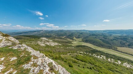 Wide panoramic view on mountain landscape with lush green hills under clear blue sky, tranquil natural beauty, perfect for outdoor enthusiasts.