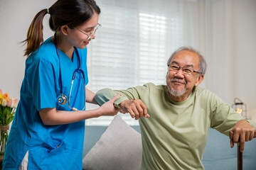 Caring nurse helping supporting senior disabled man to stand up with walking stick, young woman help support orthopedic patients to get up with walking cane at home, International Day for the Elderly