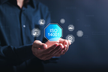 ISO 14001 concept. Businessman use smartphone with virtual ISO 14001 certified for environmental management systems (EMS). Identify, control and reduce the environmental impact of activities.