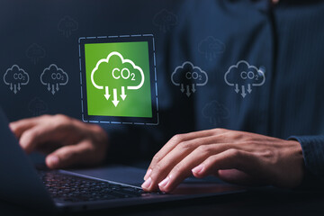 Reduce CO2 emissions. Businessman use laptop with virtual carbon reduction icon. Climate change to limit global warming and sustainable development and green business.