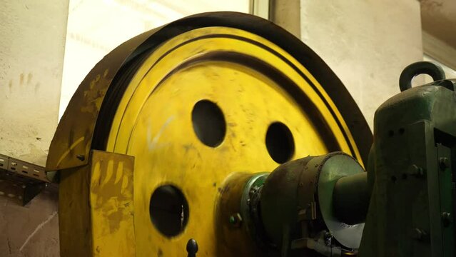Industrial rhythm: Machine wheel turns, shaping industry elements with precision in this vivid stock footage snapshot.