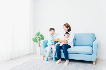 家で子どもたちと遊ぶ若い主婦