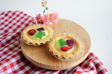Fruit Pie served on wooden board in white background. A healthy dessert dish with cream cheese filling, garnished with strawberry and jelly.