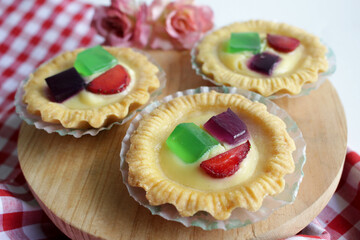 Fruit Pie served on wooden board in white background. A healthy dessert dish with cream cheese filling, garnished with strawberry and jelly.