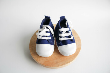 Blue baby shoes on wooden board in white background 