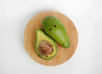 Avocado served on wooden board, isolated on white background. 