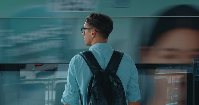 Man glasses backpack, standing station, turns train speeds, vividly embodying concept speed, capturing swift, dynamic essence modern transportation. contrast between human stillness speed