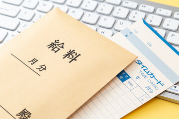 キーボードと給料袋とタイムカード