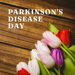 Composition of parkinson's disease day text over bunch of multi coloured tulips