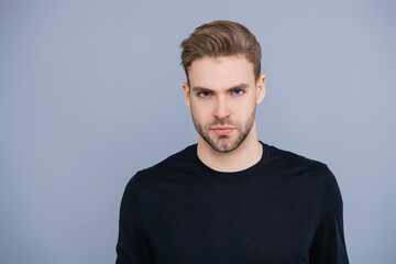 Young Caucasian man isolated on grey. Confident man face portrait. Men skin care. Skincare of men. Guy has stylish haircut. Man with trendy hairstyle. Casual male style. Copy space