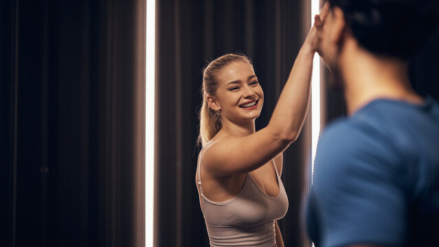 Smiling woman high-fiving her trainer after a gym workout
