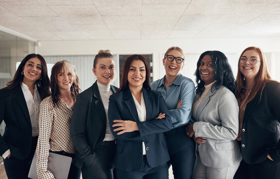 Laughing group of diverse businesswoman standing in an office boardroom
