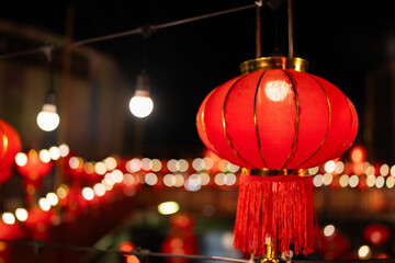 One red Chinese lantern hung on the walkway with light bulbs and bokeh. On Chinese New Year and...