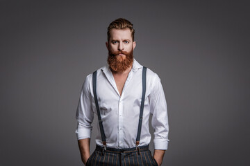 Retro man in suspenders isolated on grey. Mature redhead man with hairstyle. Vintage male fashion...