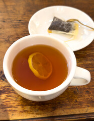 Tea with lemon in a white glass