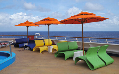 Ruheliegen oder Cabanas auf Sonnendeck von modernem Kreuzfahrtschiff - Sun loungers and deck chairs...