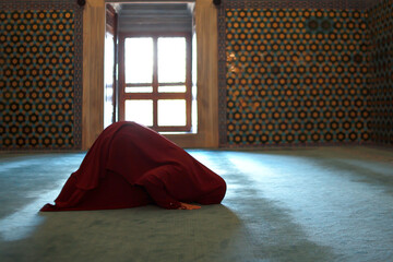 Muslim woman praying in sujud posture at mosque