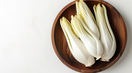 Young, raw Belgian endives on a wooden platter against a white backdrop, space, Generative AI. - obrazy, fototapety, plakaty