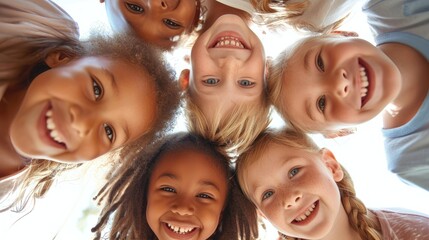 A group of children from diverse ethnic backgrounds looking down at the camera, smiling. - obrazy, fototapety, plakaty
