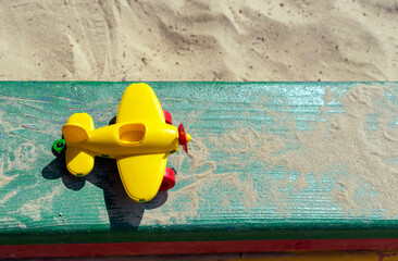Yellow airplane toy on a wooden playground