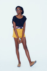 Fototapeta premium Fashion, thinking and glasses with confident black woman in studio on white background for hipster style. Model, clothes and contemplation with thoughtful young person in trendy clothing outfit