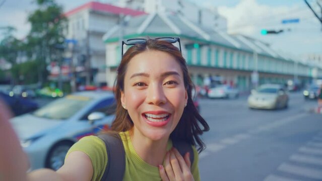 Asian woman backpacker use camera selfie and taking picture in city. 