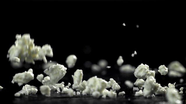Fresh cottage cheese falling on black background. Filmed on a high-speed camera at 1000 fps. High quality FullHD footage