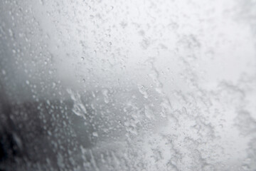 Snow and ice water drop on car glass door, winter car glass background.