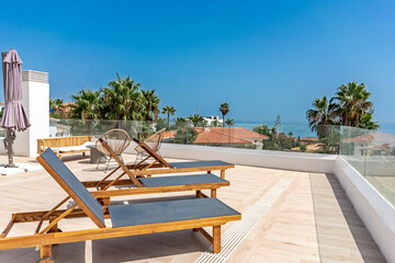 a set of sun lounges with sea views on a luxury rooftop terrace in mediterranean apartment 