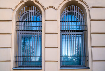 Windows with bars in the wall of an ancient building.