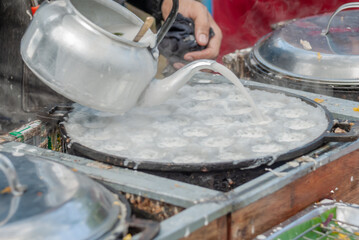 Thai Pancake, Male hands making khanom krok Traditional Thai desserts with delicious - obrazy, fototapety, plakaty