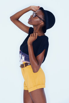 Fashion, glasses and hat with profile of black woman in studio on white background for hipster style. Model, clothes and eyes closed with relaxed young african person in trendy clothing outdoor