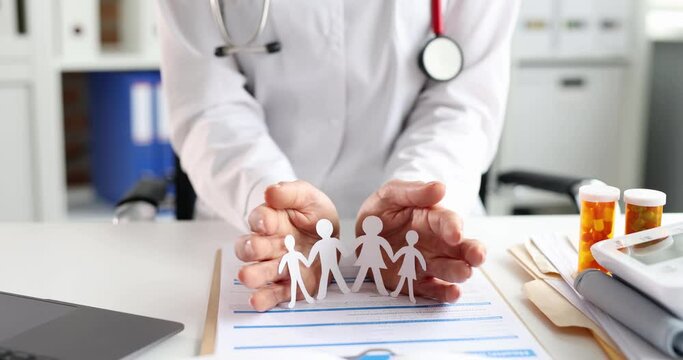 Doctor surrounding paper men with hands in clinic 4k movie slow motion. Family medicine concept