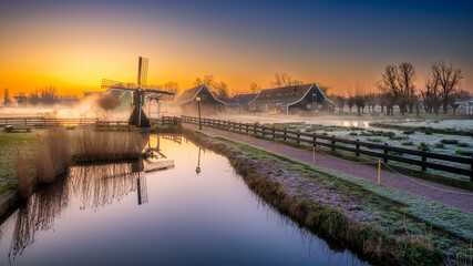 View of the windmills of Zaanse Schans shrouded in fog at dawn. Holland, Netherlands