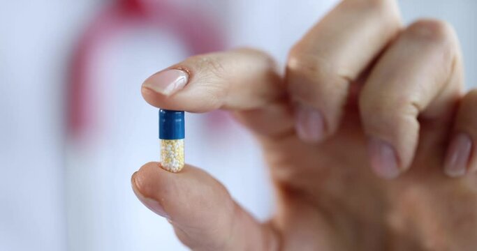 Doctor holding capsule of medicine in hand 4k movie slow motion. Pharmaceutical business concept