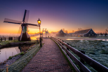 View of the windmills of Zaanse Schans shrouded in fog at dawn. Holland, Netherlands