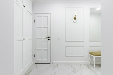 White entrance hall interior with wooden banquette with gold top