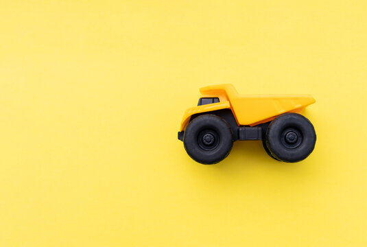 A dump truck miniature isolated on yellow background. After some edits.
