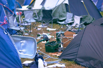 Tents, trash and mess at an outdoor music festival or event for a celebration party or social...