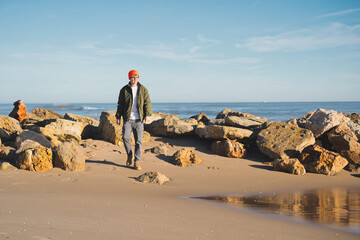 Lonely young man walking on the beach in the morning. The concept of depression and loneliness.