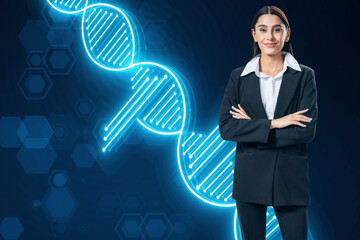 Happy young european businesswoman with folded arms and glowing DNA helix on blurry blue...