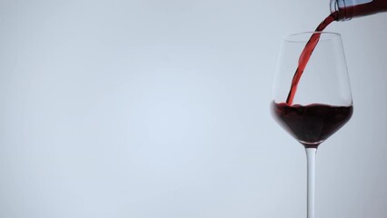 Wine pouring in wine glass on white background