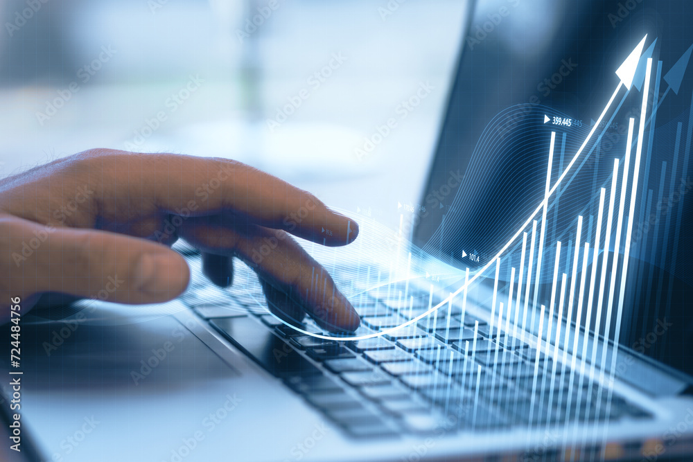 Poster close up of businessman hand using laptop keyboard with growing business chart hologram on blurry bl