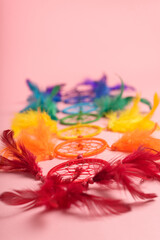 Colorful dreamcatcher on pink background. Dreamcatcher with colorful feathers.