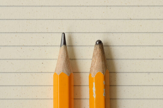Sharp pencil and dull pencil on lined notebook paper - Concept of success, innovation and creativity